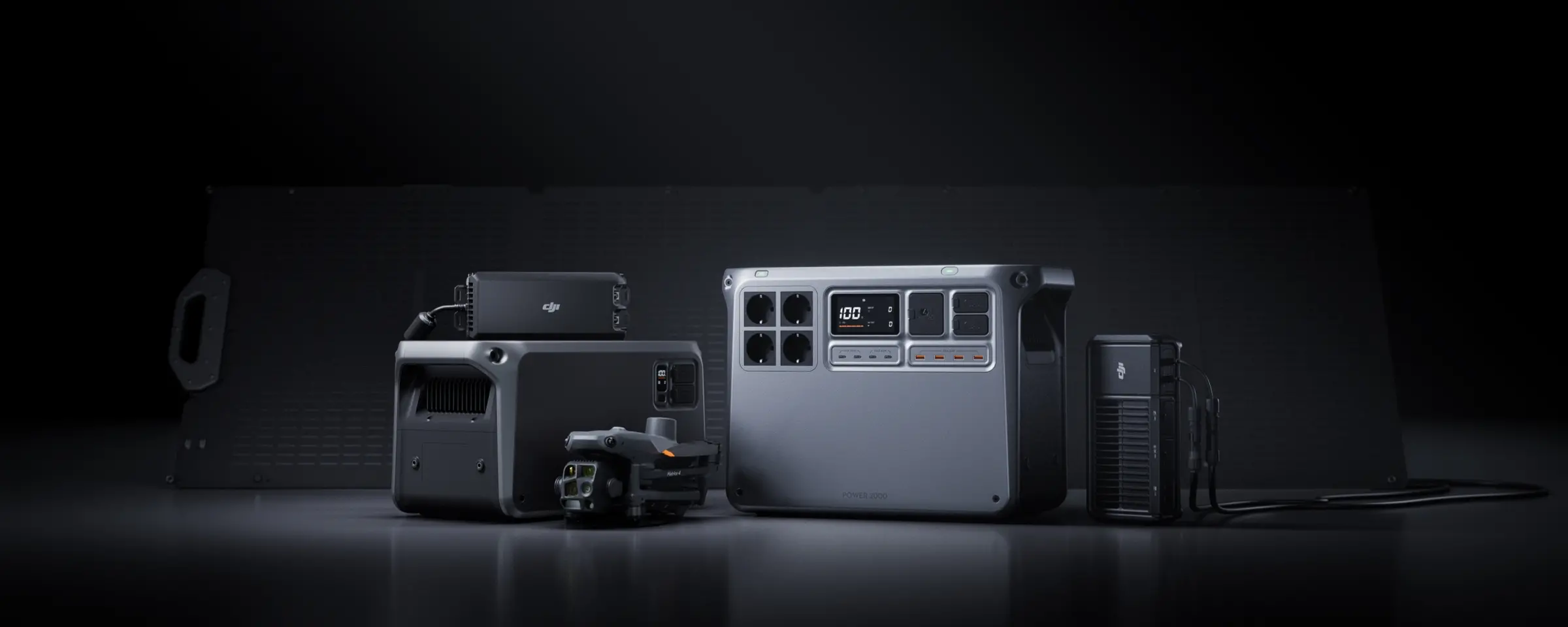 En samling av DJI Power-enheter inklusive en drönare, kraftstation och tillbehör, arrangerade mot en mörk bakgrund.