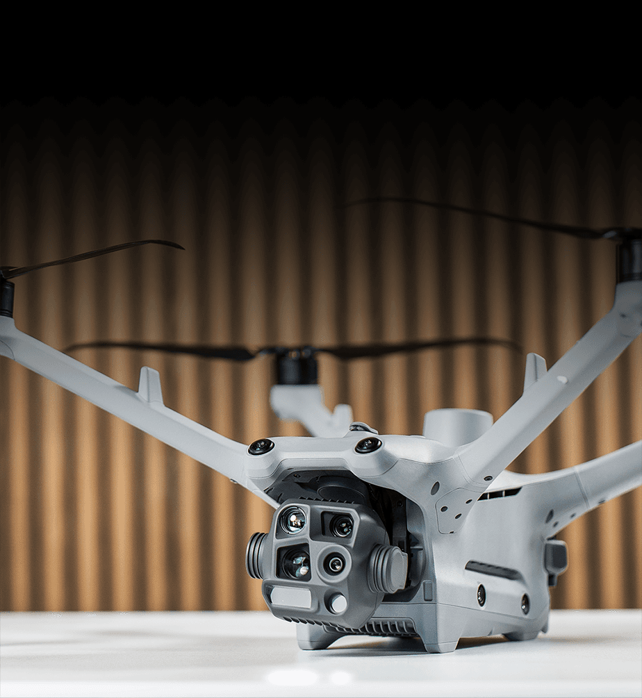 En avancerad DJI Matrice 4TD-drönare med flera kameror och sensorer visas mot en träpanelbakgrund.